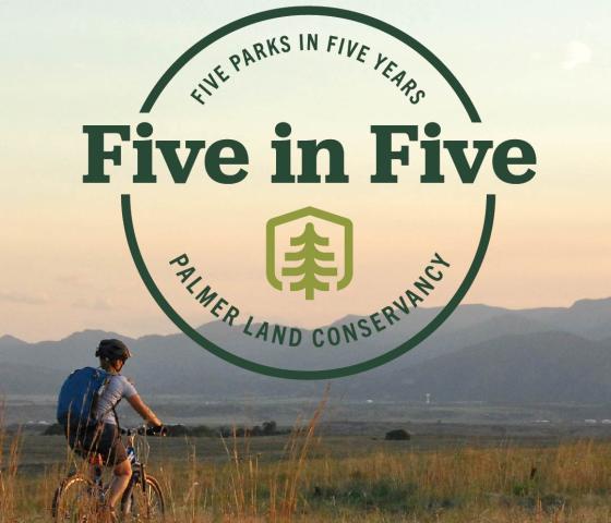 Image of mountain biker on trail with mountains in the distance. Five in Five badge overlaying the image. 