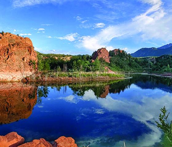 Image of Red Rock Canyon with towering red rocks and water.