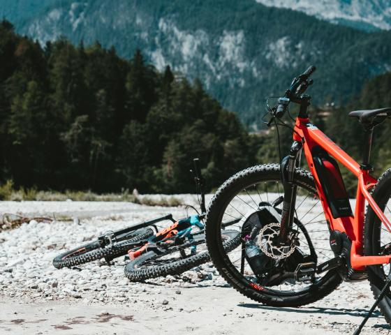 two e-bikes sit next to a trail