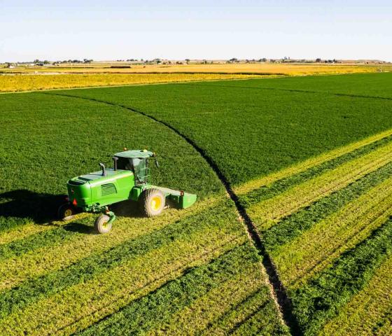 Aerial photo of a verdant farm with a green tractor in the field