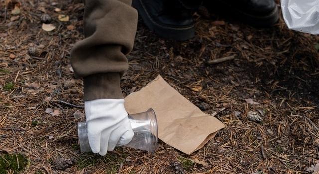 picking up plastic bottle from ground